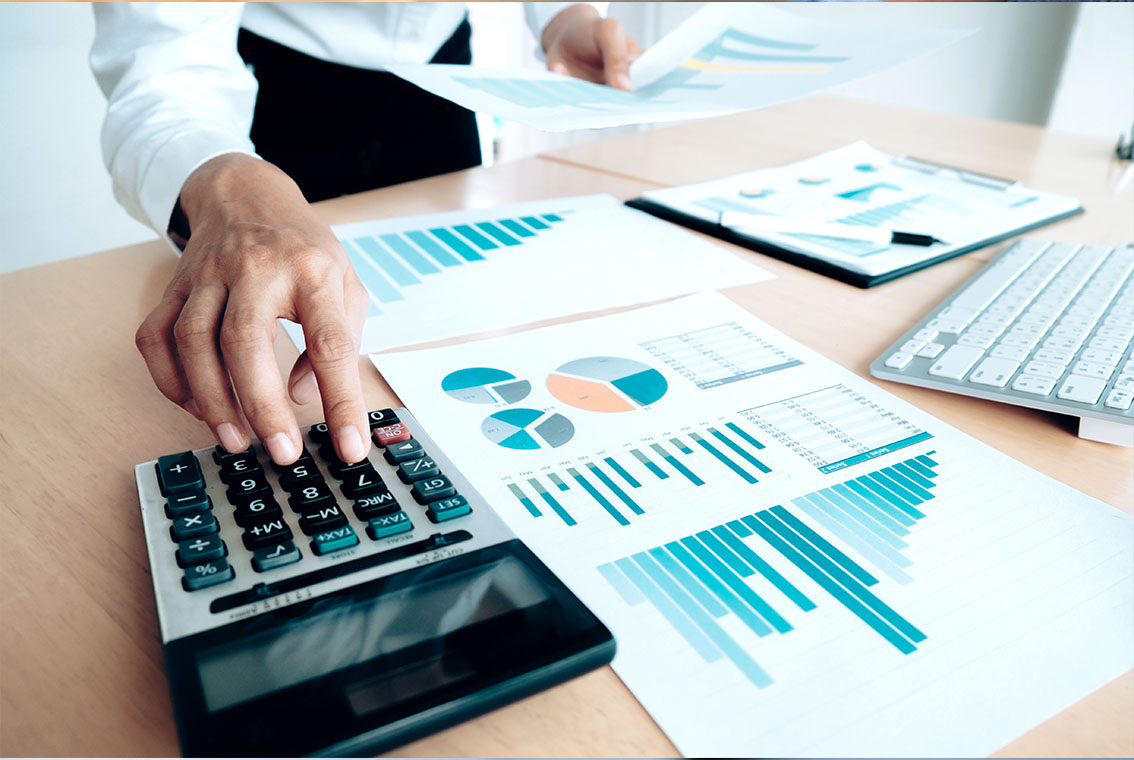 Close-up of business accountant using calculator while working i